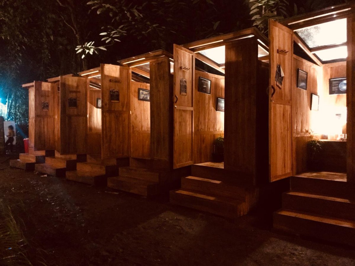 Ecoranah teak composting toilets lit from inside at night